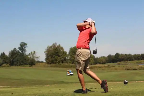 Golfer teeing off during a luxury golf trip with Golf Transfers in Northern Ireland