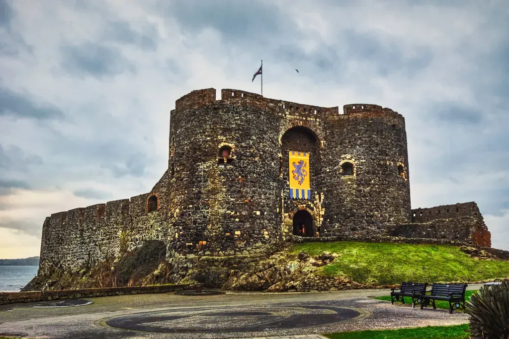 The twin towered gatehouse of Carrickfergus Castle with a heraldic banner hanging over the entrance
