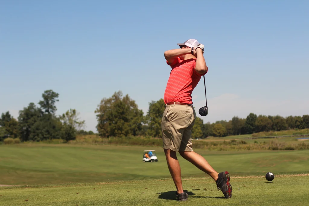 Golfer teeing off during a private golf tour transfer in Northern Ireland