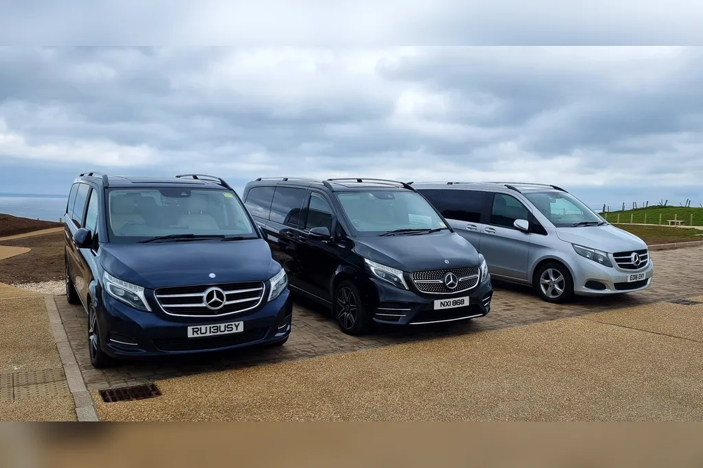 Three Belfast Tours NI Mercedes-Benz V-Class vehicles parked on the Causeway Coast